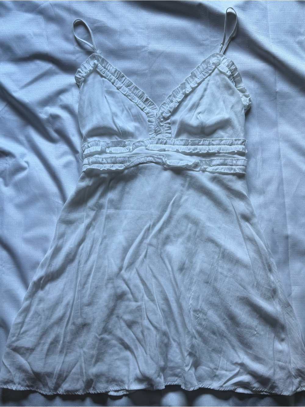 White ruffle mini dress with adjustable straps, size M. Rayon & polyester blend.